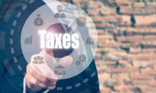 Businessman pressing an Taxes concept button on a circular display.
