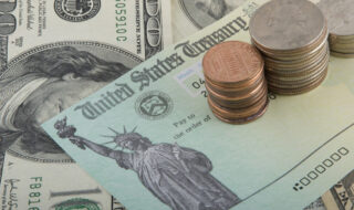 Social Security Check and U.S. Currency on top of it.