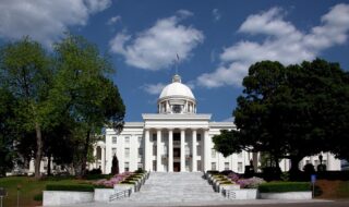 The first Capitol building in Montgomery, Alabama was built in 1847, and was destroyed by fire in 1849. The current State Capitol was built on the previous Capitol's foundations, and was completed in 1851. The building has grown over time with an east wing added to the buildings rear in 1885, a south wing in 1906, a matching north wing in 1912, and along with a complete renovation to the whole building a modern addition to the rear in 1992.
