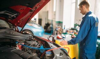 Mechanic pumps freon into the conditioning system