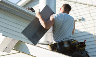 Roofer installing new roof on house